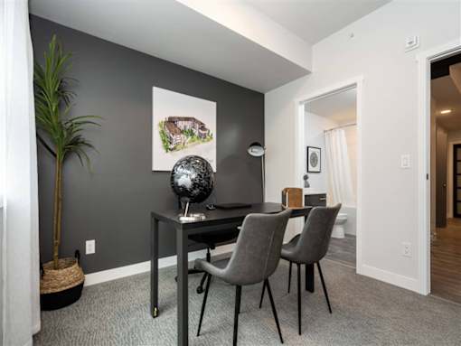 A dining room with a table and chairs.