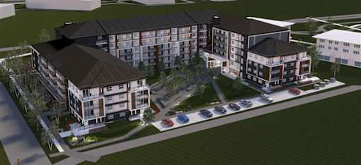 A large, modern building with a parking lot in front.