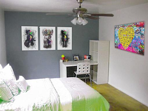 A bedroom with a bed, desk, and three pictures on the wall.