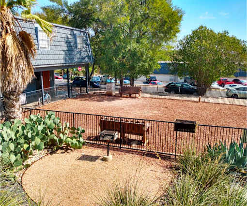 A park area with a bench and a fence.
