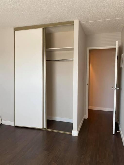 A white closet with a brown door is open.