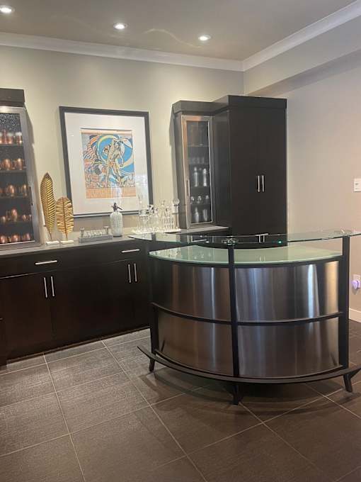 A modern kitchen with a curved glass island and dark wood cabinets.