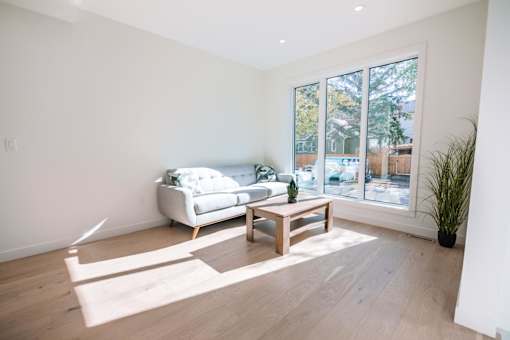 A living room with a white couch and a wooden coffee table.