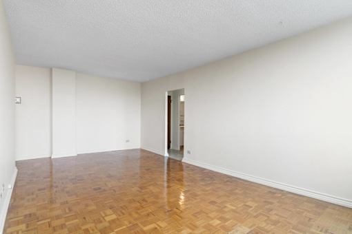 A room with a wooden floor and a door on the right side.