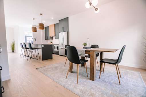A modern kitchen with a dining table and chairs.