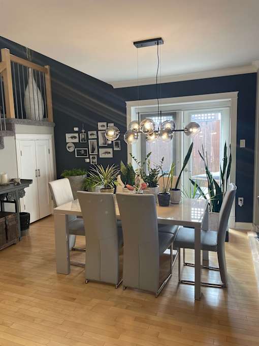 A dining room with a table and chairs.