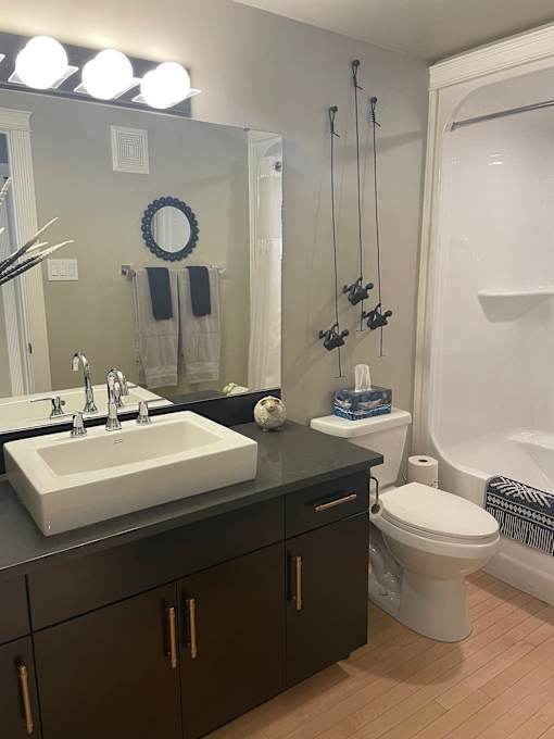 A bathroom with a white sink and a white toilet.