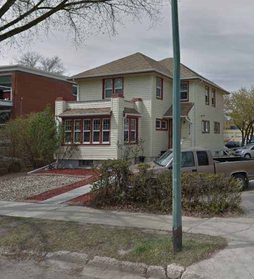 A house with a red brick building next to it.