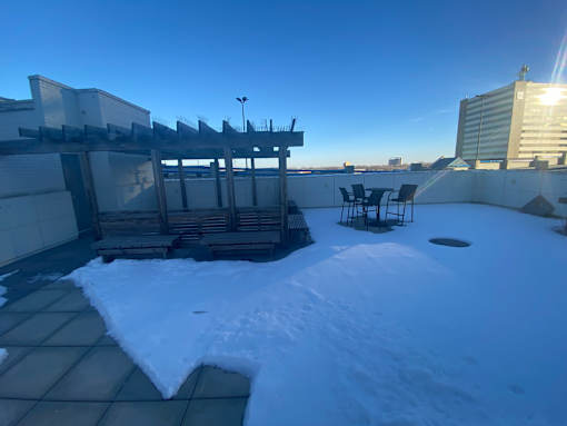 A snow-covered rooftop with a table and chairs.