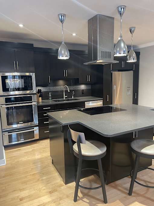 A modern kitchen with a large island and stainless steel appliances.