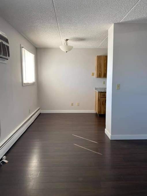A room with a window and a wooden door.