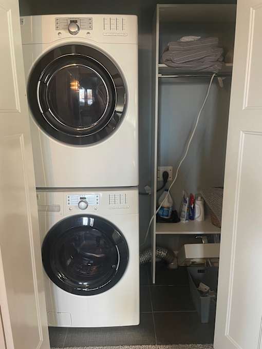 A white washing machine is in a small laundry room.