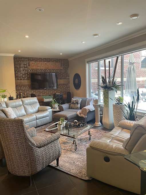 A living room with a brown chair and a white couch.