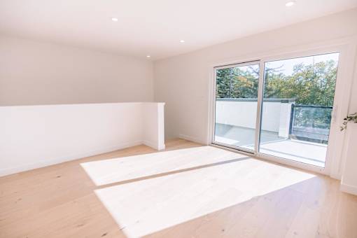 A room with a large window and wooden flooring.