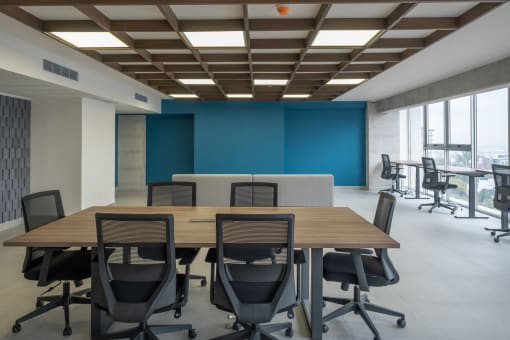 a conference room with a wooden table and chairs and a blue wall