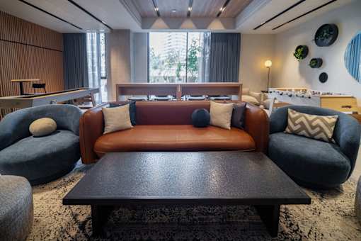 A living room with a brown couch and blue chairs.