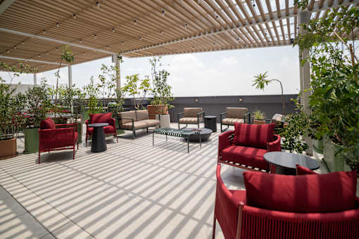 A patio with red chairs and tables.