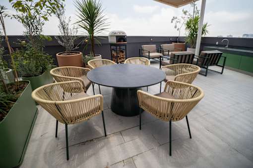 A round table surrounded by chairs on a patio.