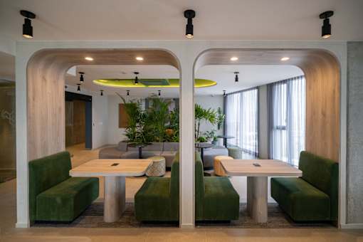 A modern dining area with green chairs and a white table.