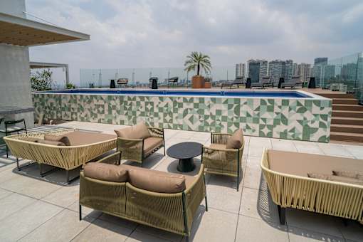 A patio with a table and chairs overlooking a pool.