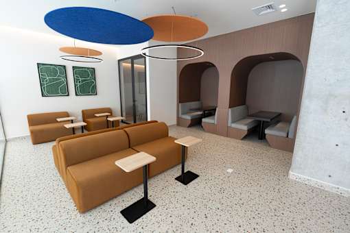 A room with a brown couch and a white table.
