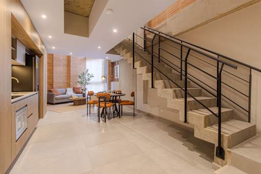 A modern home interior with a staircase and a dining table.