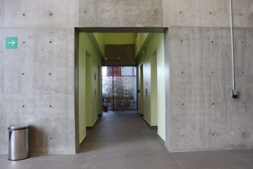 a long hallway with green walls and a door to a bathroom