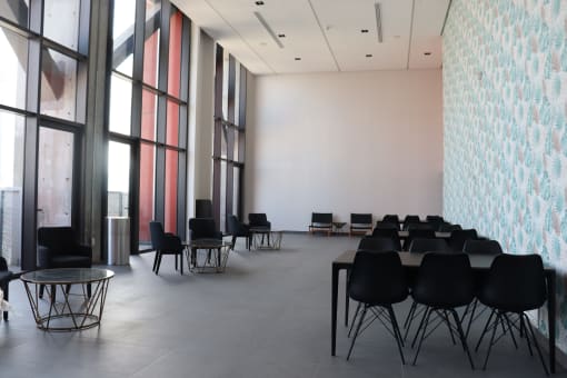 a large room with tables and chairs and large windows