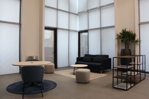 a lobby with chairs and tables and a large window