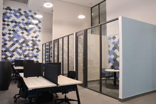 a conference room with tables and chairs and a partitioned wall