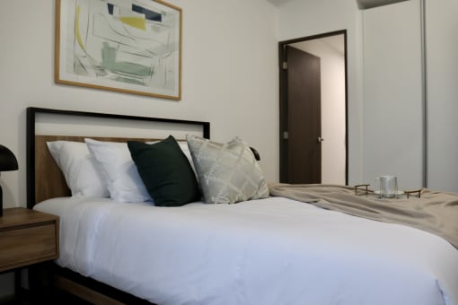 a white bed with pillows in a hotel room