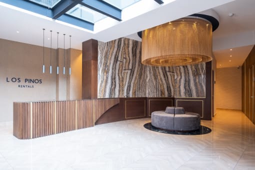 a large drum chandelier hangs from the ceiling in the lobby of the los pines