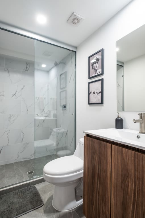 a bathroom with a toilet sink and shower in a 555 waverly unit