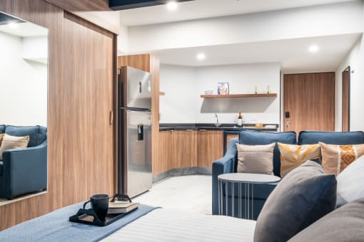 a living area with a sofa coffee table and a kitchen in the background