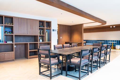 a long table with chairs and a bookshelf