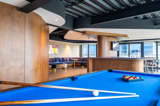 a pool table and bar in a lounge area