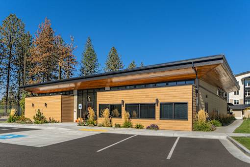 A modern building with a parking lot in front.