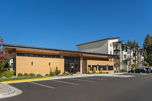 A modern building with a parking lot in front.