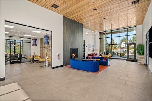 A spacious lobby with a blue couch and a fireplace.