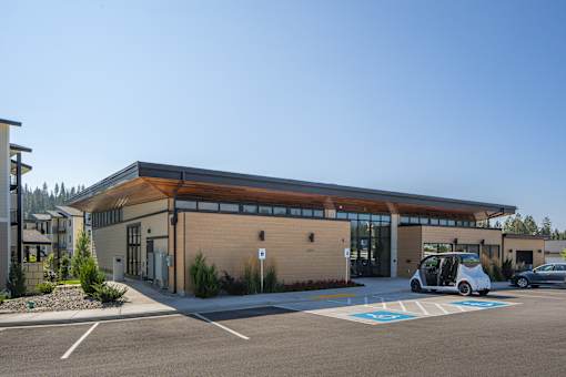 A modern building with a parking lot in front.