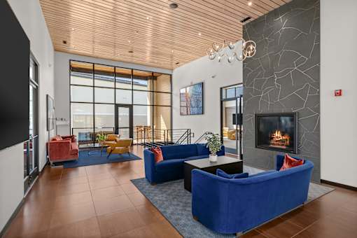 A living room with a blue couch and a fireplace.