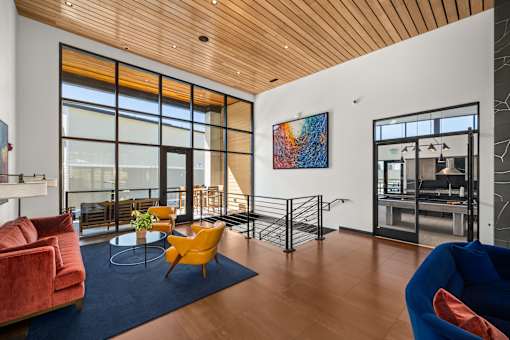 A living room with a red couch, yellow chair, and a blue chair.