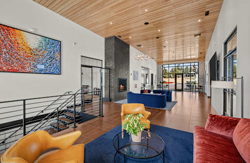 A living room with a blue rug and a yellow chair.