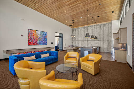 A large room with yellow chairs and a blue couch.