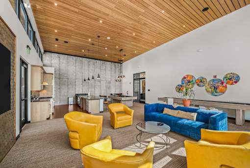 A modern living room with a blue couch and yellow chairs.
