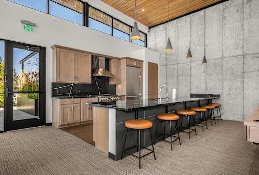 A kitchen with a bar area and a green exit sign on the wall.