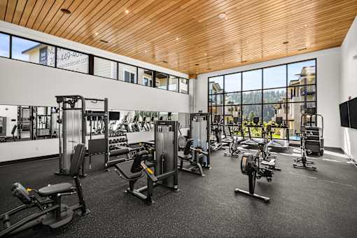 A gym with a variety of equipment including treadmills, weights, and exercise machines.