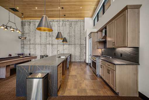 A modern kitchen with wooden cabinets and a marble island.