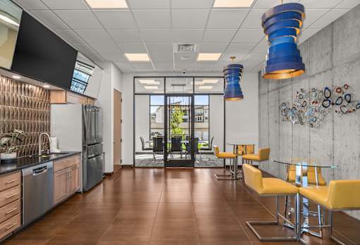 A modern kitchen with a glass door refrigerator and a dining table with chairs.