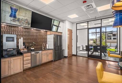 A modern kitchen with wooden floors and a large window.